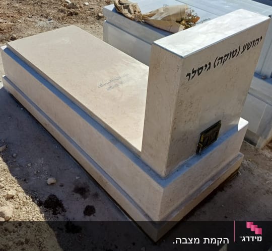 מצבת שיש ואבן בהירה עם כיתוב חרוט ובית נר מובנה